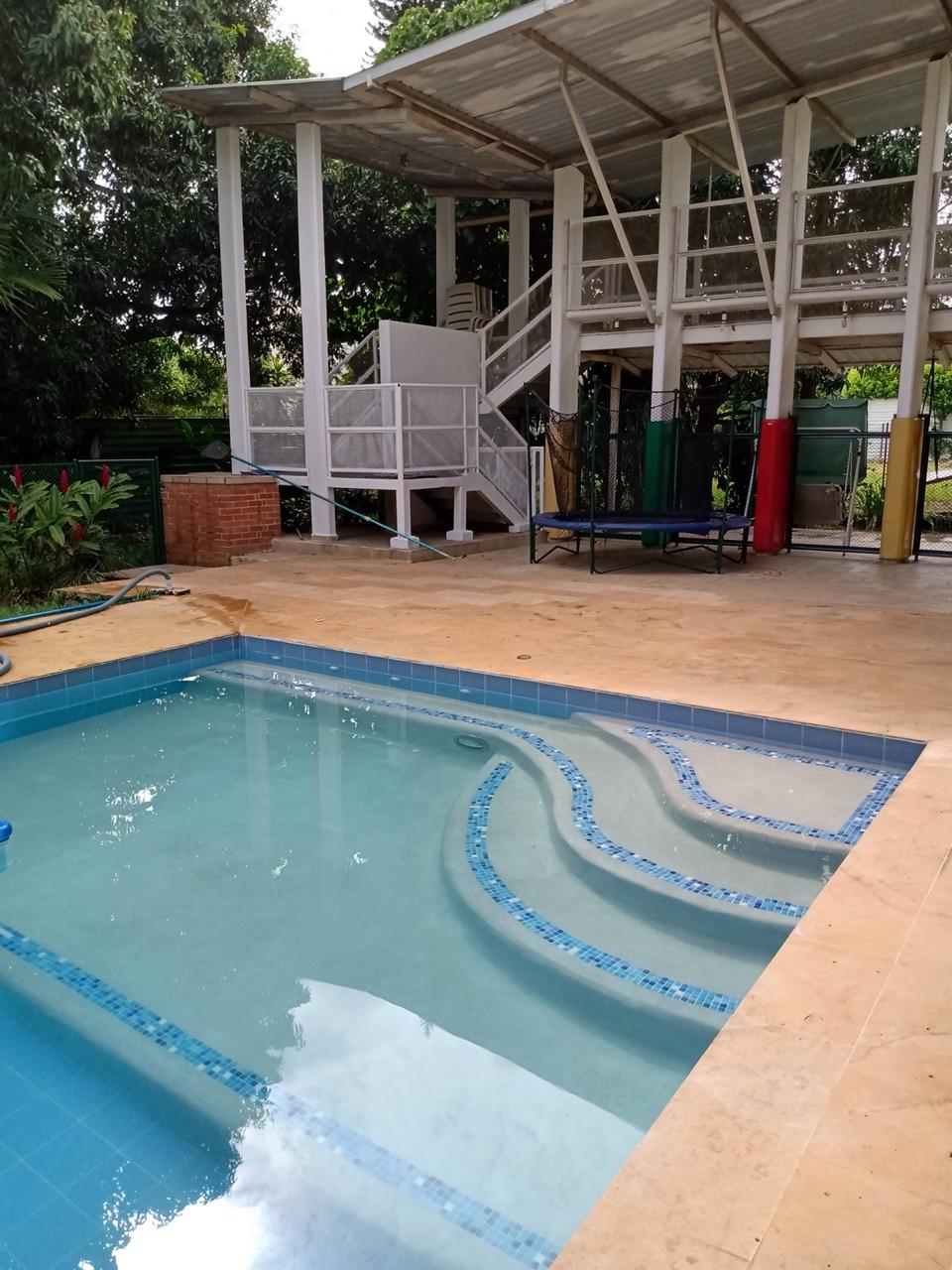 Piscina residencial con banca de mosaico curva