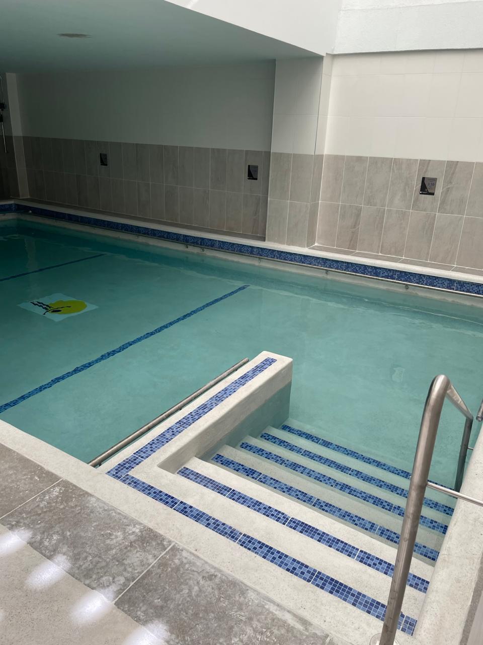 Piscina institucional de rehabilitación — acceso con doble pasamanos